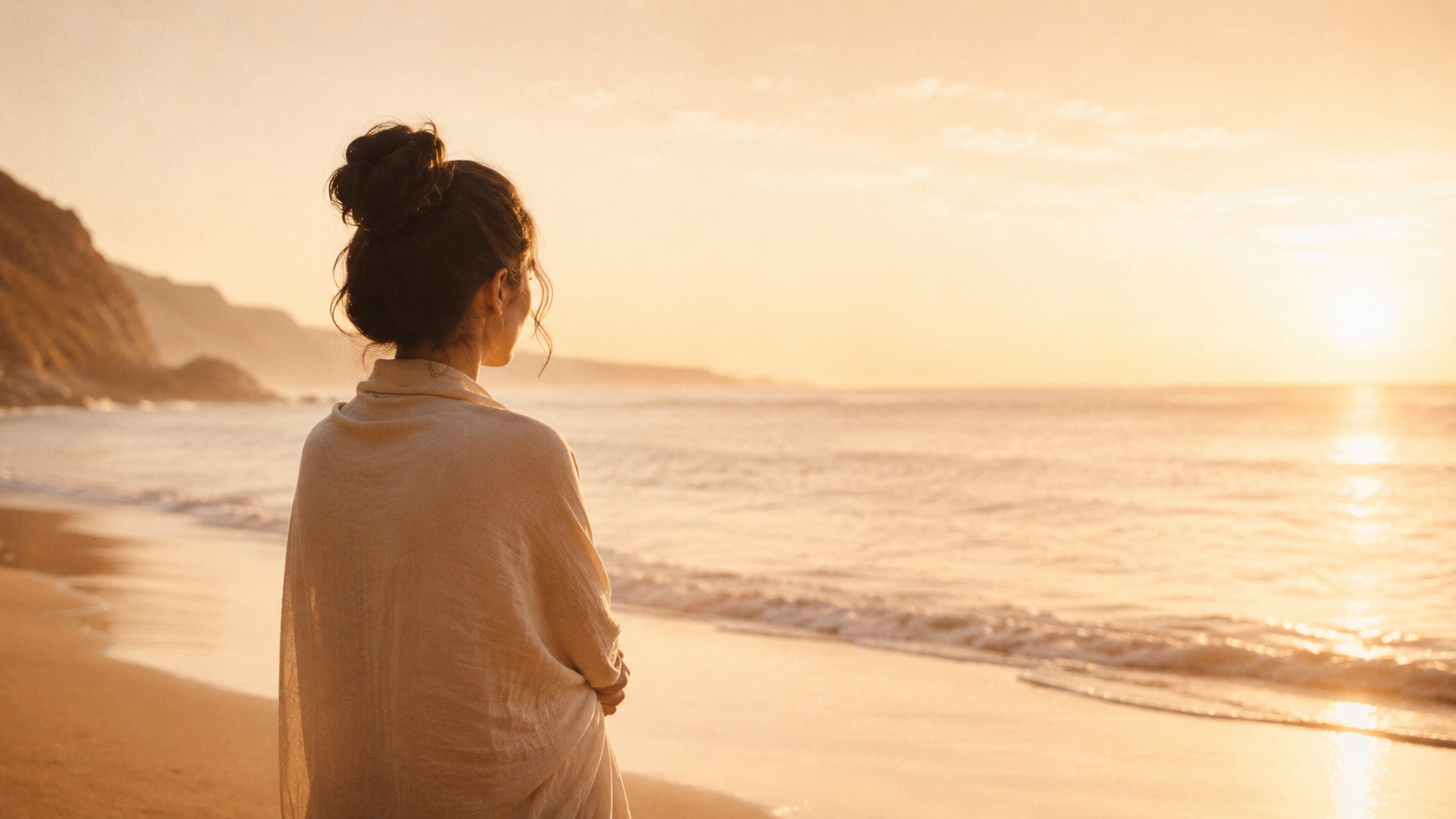 A woman at the ocean in warm morning light, reflecting on healing father wounds and family grief.